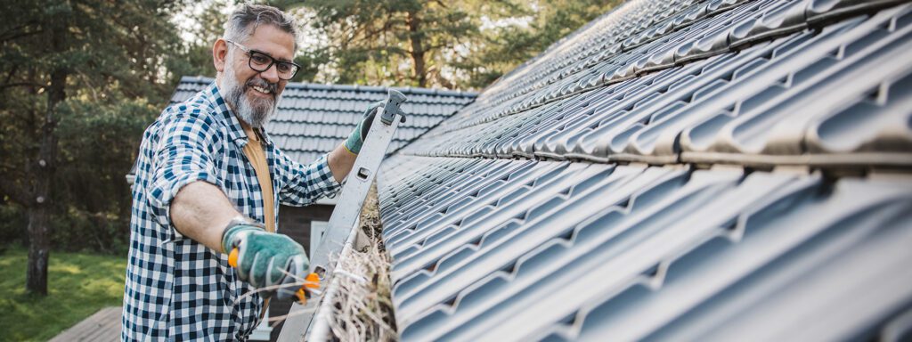 Cleaning Gutters in the fall, removing needles and leaves to prevent water damage or Ice Damming